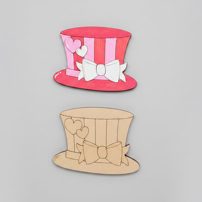 a painted MDF cutout of a top hat with stripes, hearts and a bow