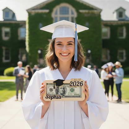 graduate wearing a white cap and gown and holding a wooden money holder