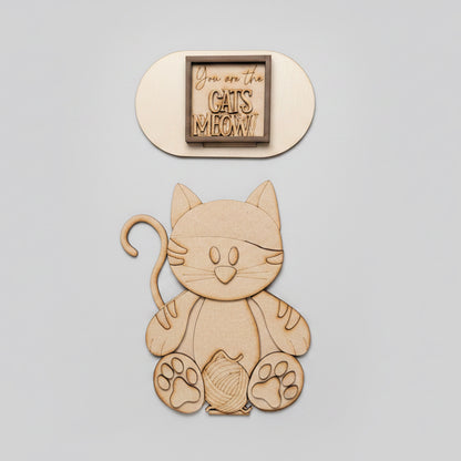 Wooden cat-shaped cutout with 'You are the CATS MEOW' text on a brown background