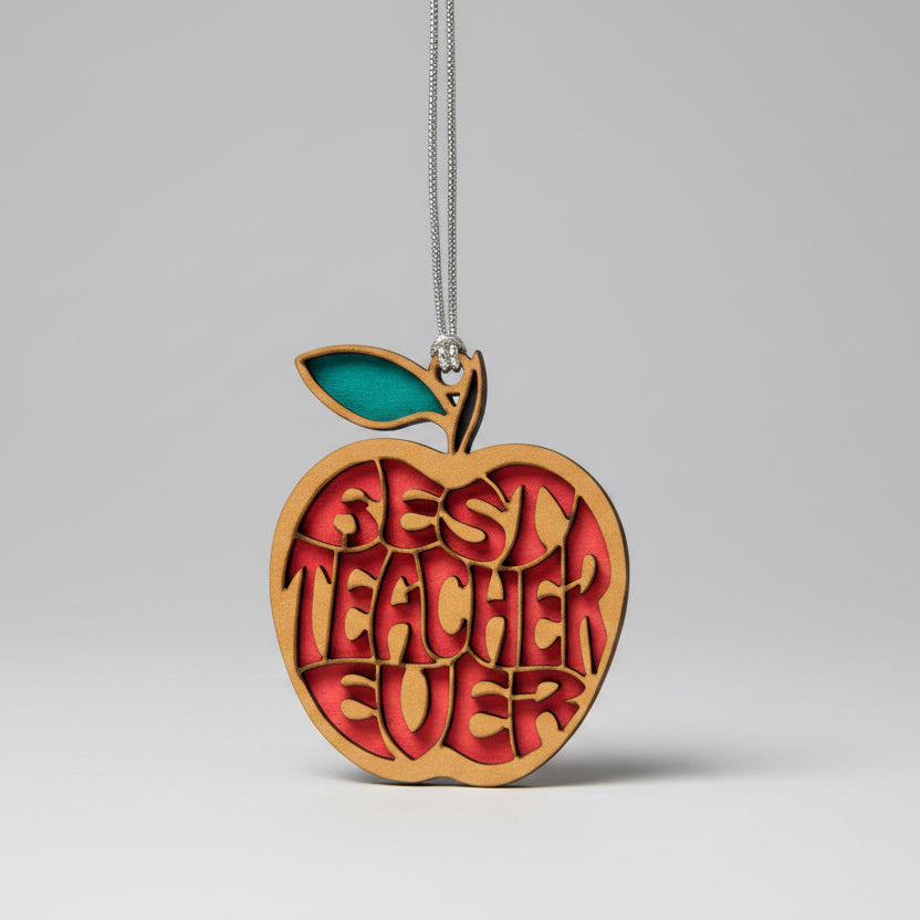 Wooden apple-shaped ornament with 'Best Teacher Ever' text on a beige background