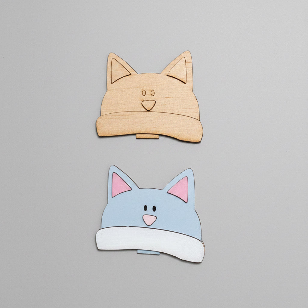 Cardboard cutout of cat-shaped boxes on a cardboard surface with additional cutouts below.