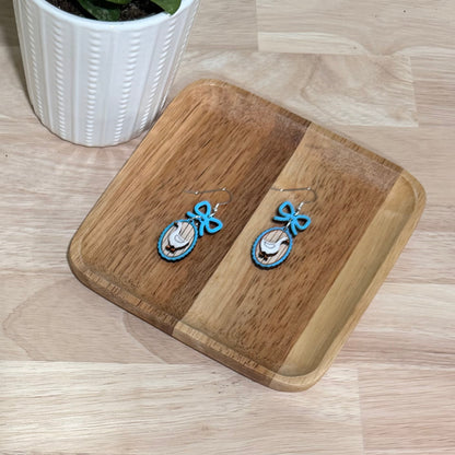 Handmade wood earrings displayed on a wooden stand. Each earring features a goose frame with a bow, crafted from birch wood with a gloss finish. Available in various colors including autumn red, mint green, and baby blue. The earrings come in different styles such as fish hooks, studs, and clip-ons, perfect for adding a whimsical touch to any outfit.