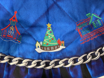 Northpole Village tree skirt with a sketch style embroidery on a blue background.