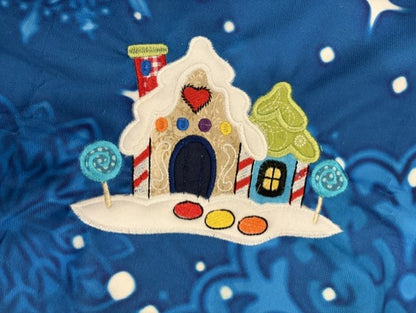 Northpole Village tree skirt with applique embroidery on a blue background.