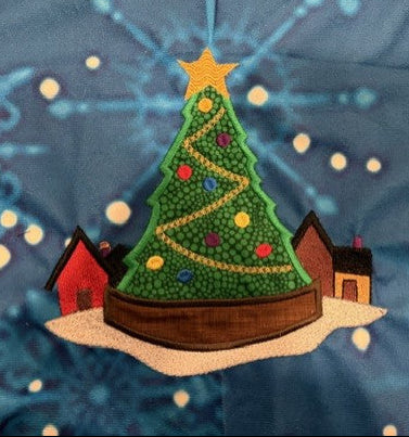 Northpole Village tree skirt with applique embroidery on a blue background.