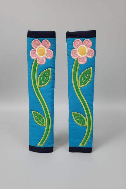 Pair of blue seat belt covers with pink flowers