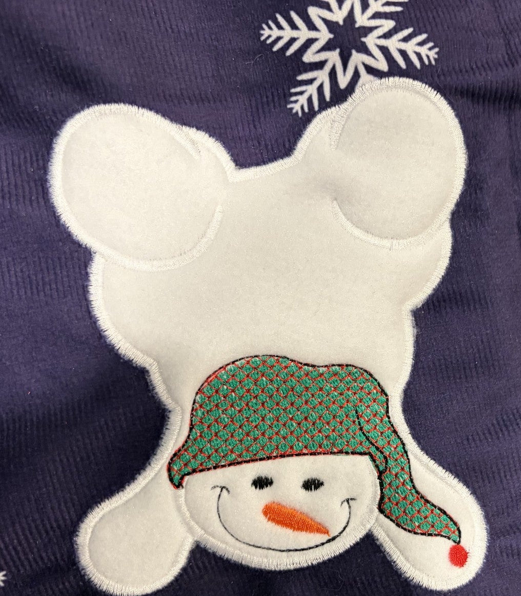 Snowmen tree skirt with applique embroidery on a blue background.