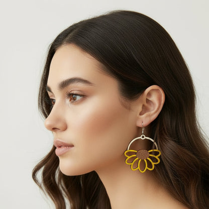 Yellow flower-shaped earrings on a white plate with yellow flowers around.