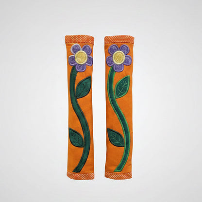 Floral design door handle covers on a metallic surface