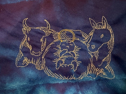 Nativity tree skirt with a blue background.