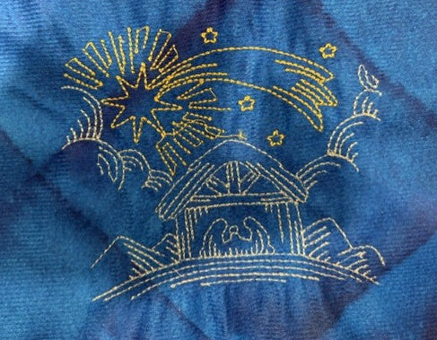 Nativity tree skirt with a blue background.