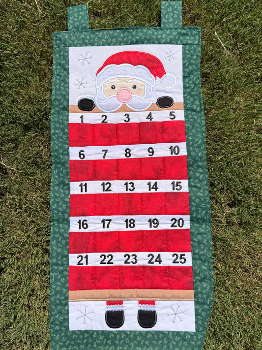 Handcrafted fabric Santa Advent Calendar featuring numbered pockets and detailed holiday embroidery. Santa has light skin in this picture.