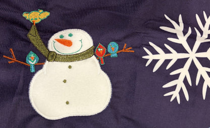 Snowmen tree skirt with applique embroidery on a blue background.