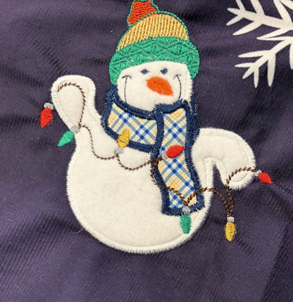 Snowmen tree skirt with applique embroidery on a blue background.