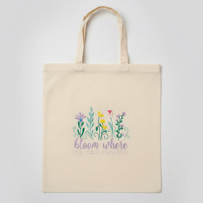 Beige tote bag with floral design and text on a black background